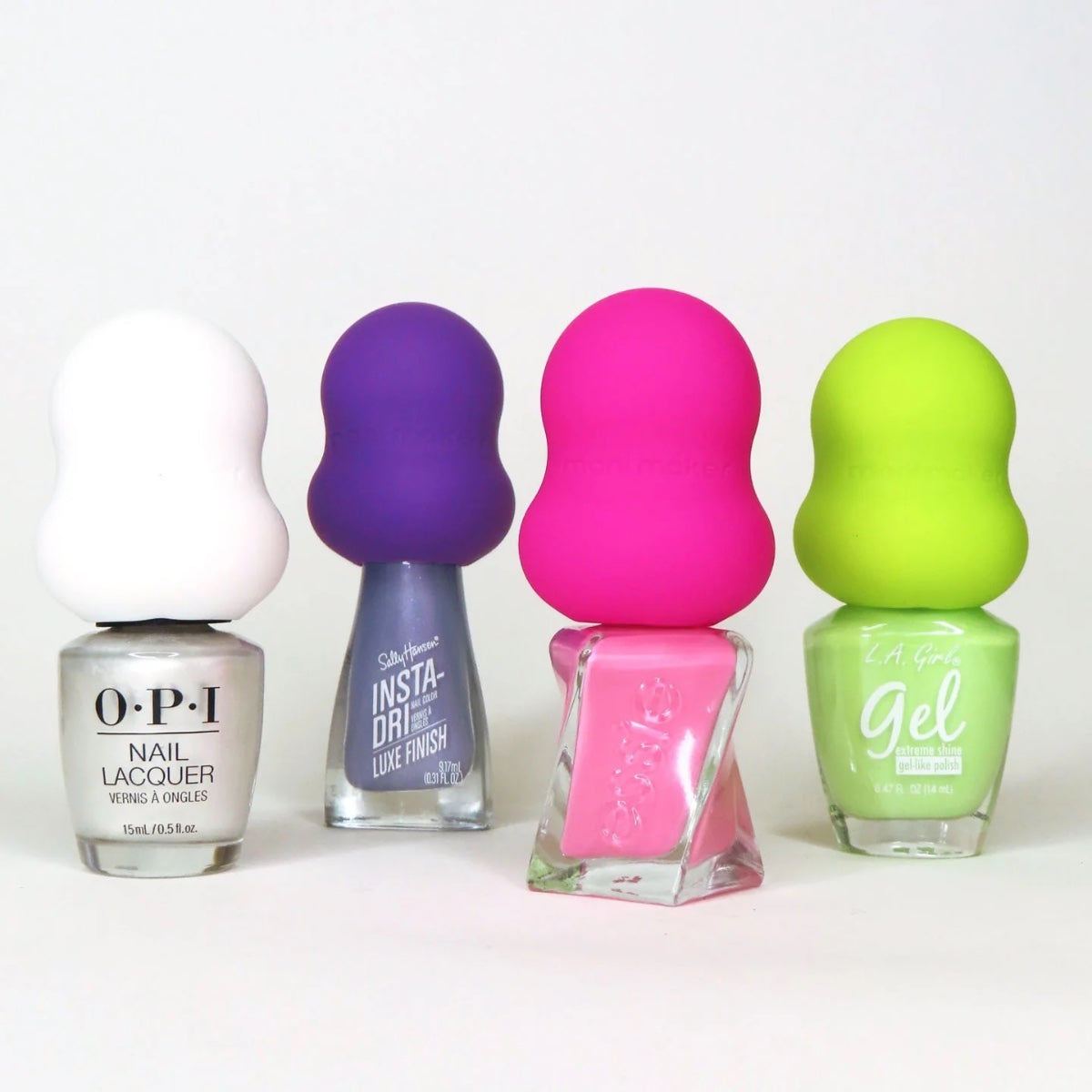 Dermelect Mani Maker base coat styled among four nail polish bottles with colorful silicone bulb caps on white