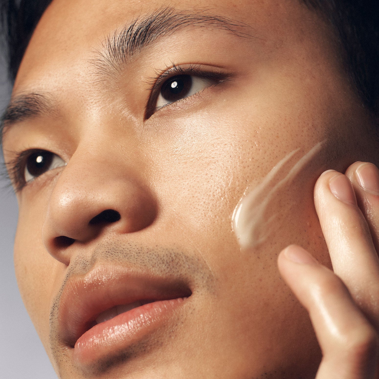 Closeup of man applying Philosophy Purity Made Simple moisturizer to smooth skin