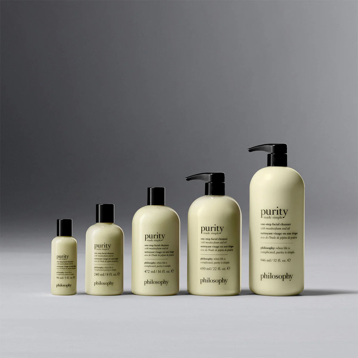 Philosophy purity facial cleanser bottles in five different sizes with pump and flip caps on gray background