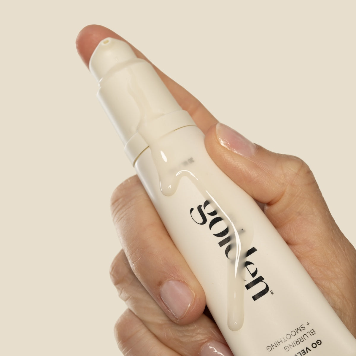 Close-up of hand holding All Golden Go Velvet Primer 1 oz with product texture on tube