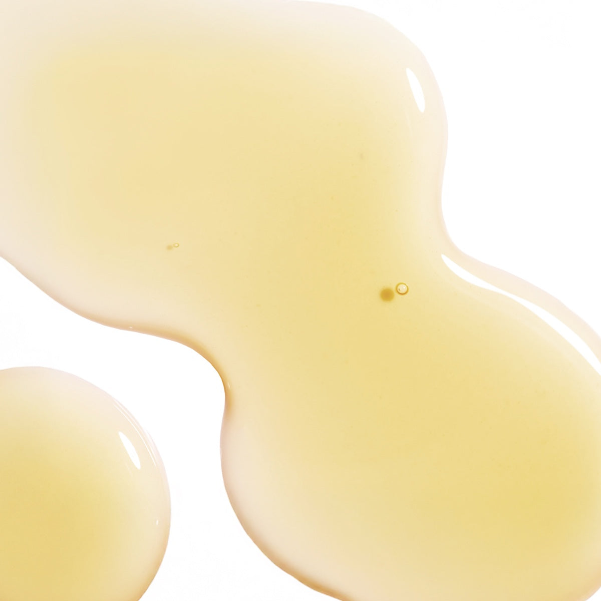 Close-up of All Golden firming face serum with peptides texture in light yellow translucent liquid