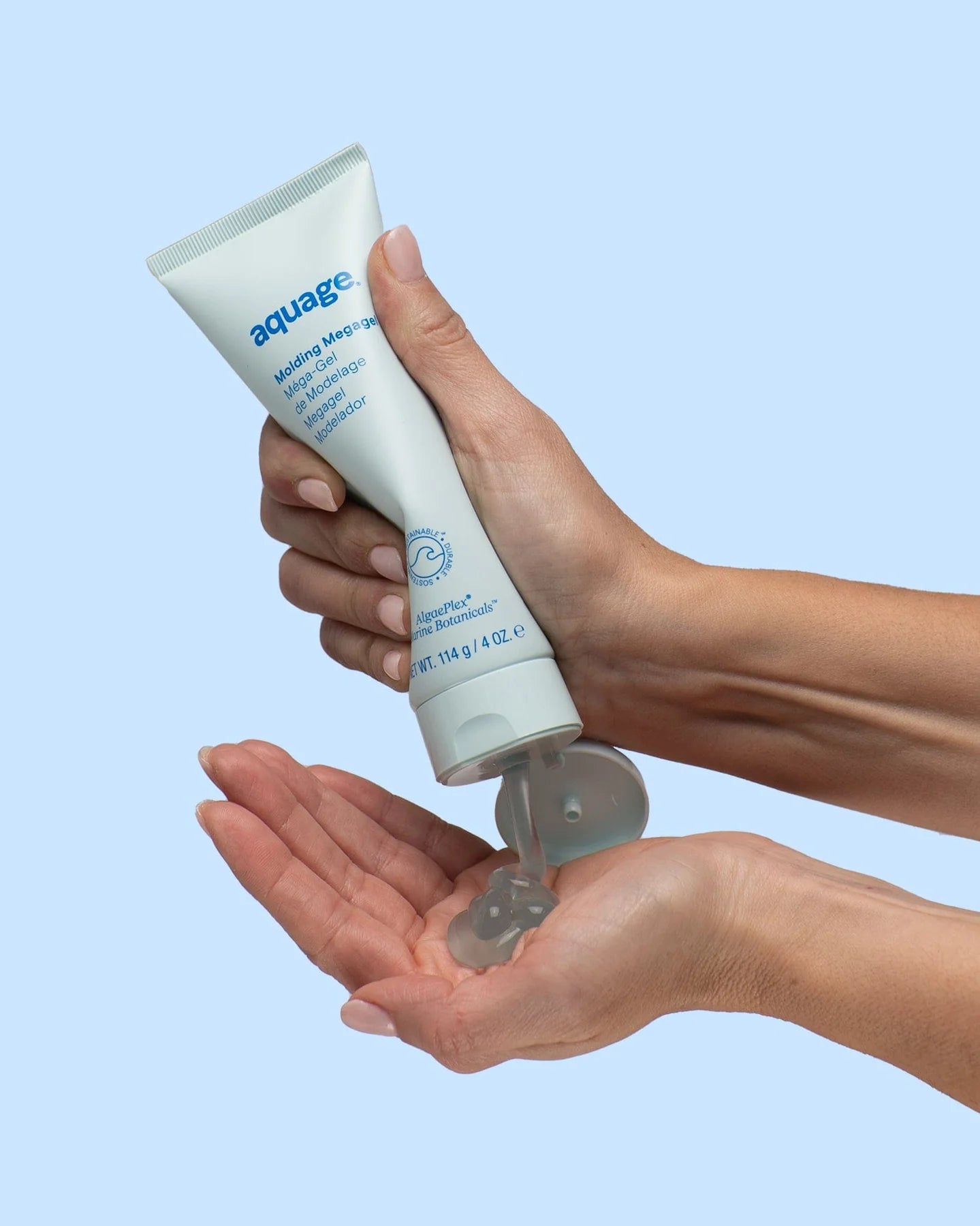 Aquage Molding Megagel 4 oz tube being squeezed to dispense styling gel into hand