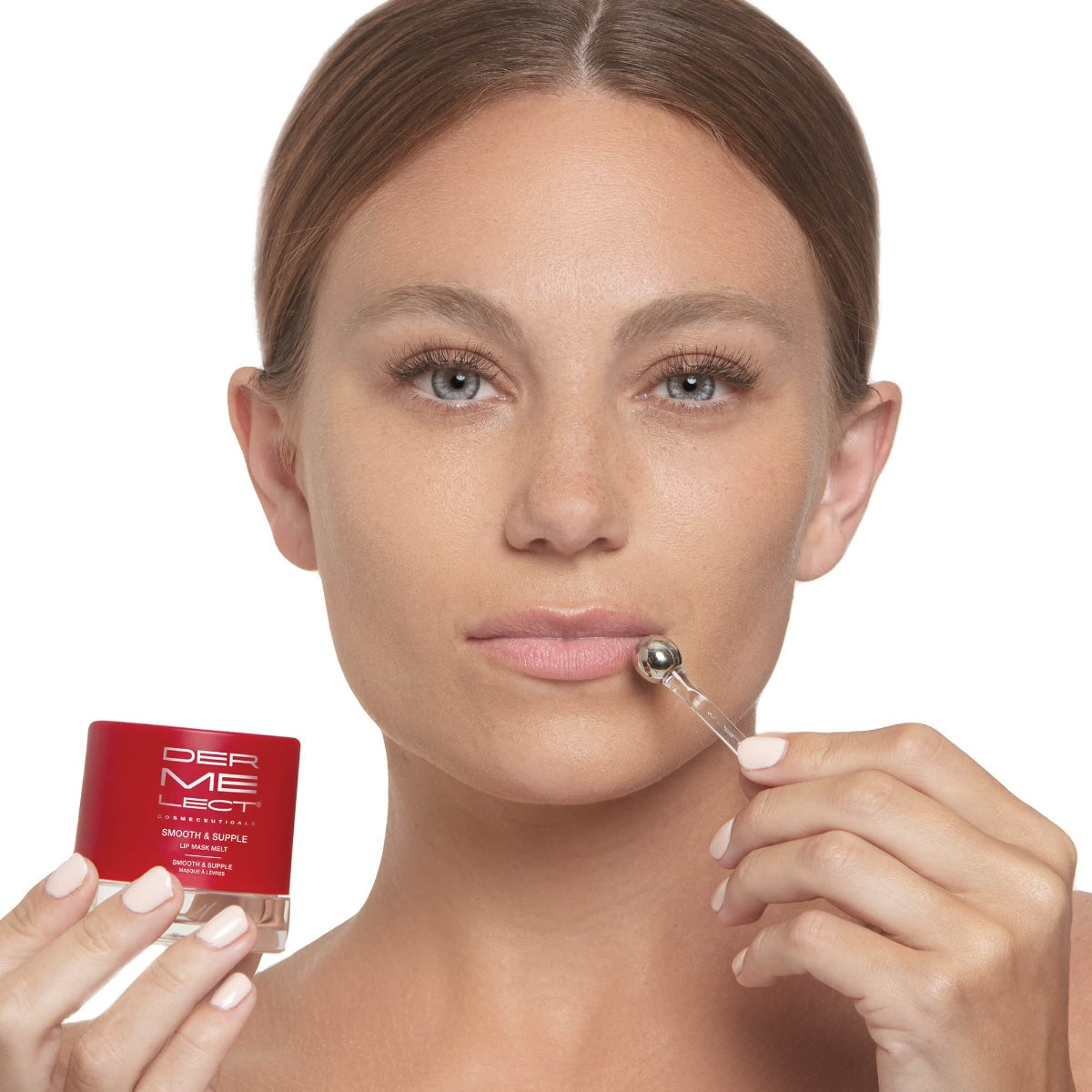 Model applying Dermelect lip mask melt with metal applicator while holding red Dermelect jar for hydrating lips