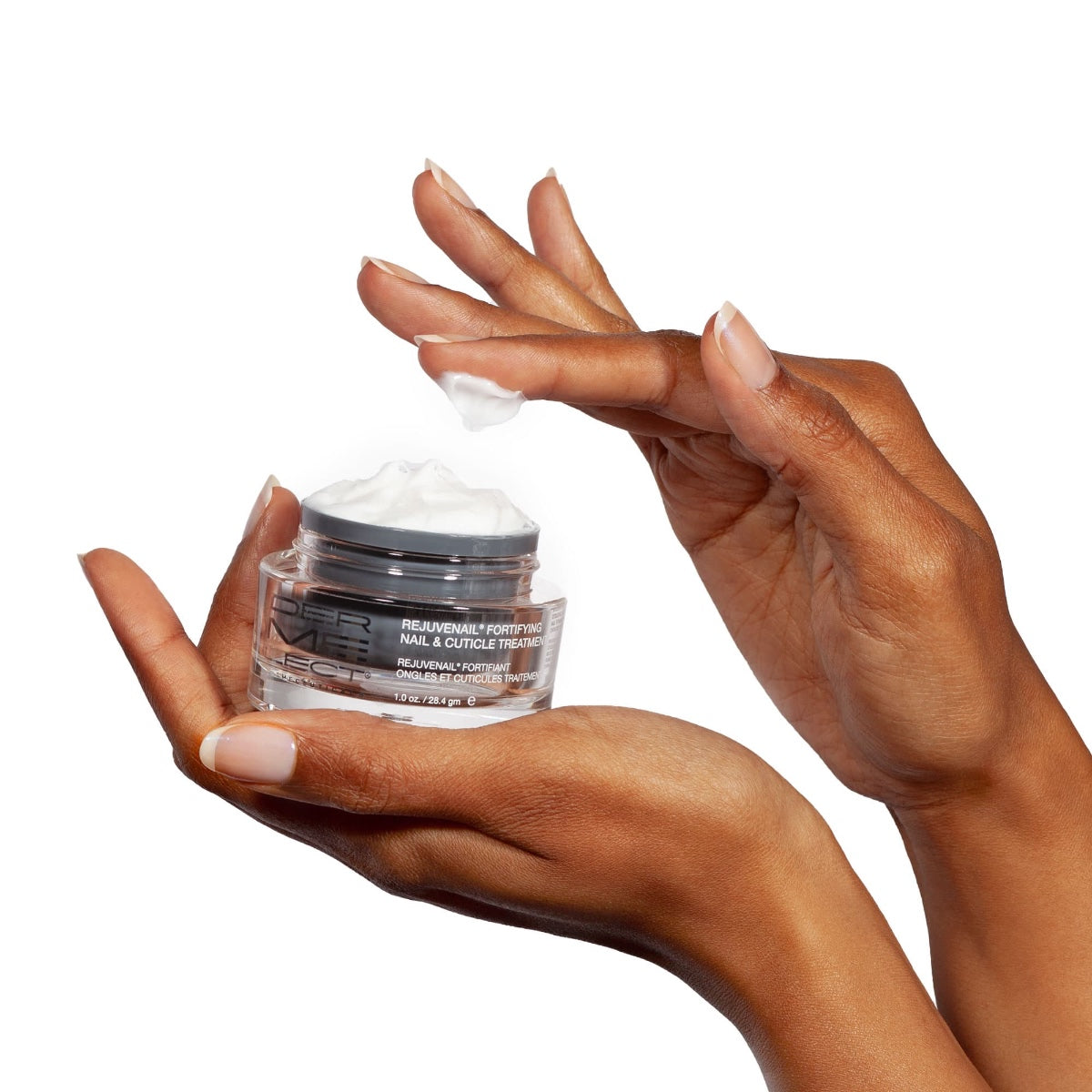 Hands holding jar of nail and cuticle cream with finger applying cream Dermelect Rejuvenail fortifying treatment