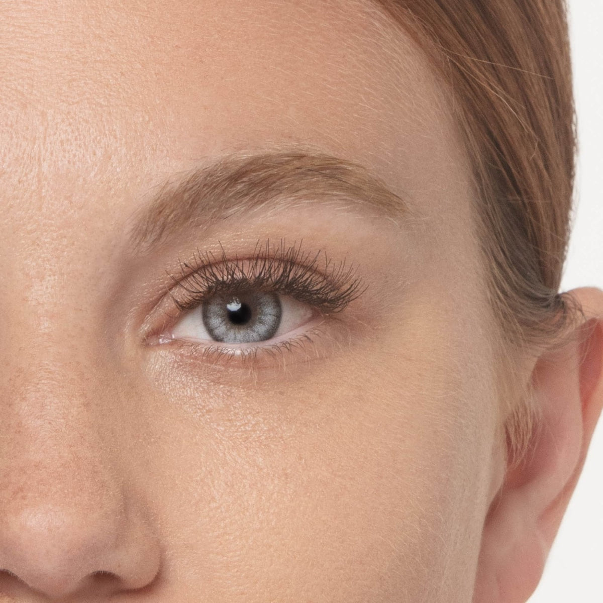 Dermelect XL Lash Volumizer shown on close up of blue eye with long full lashes and natural makeup