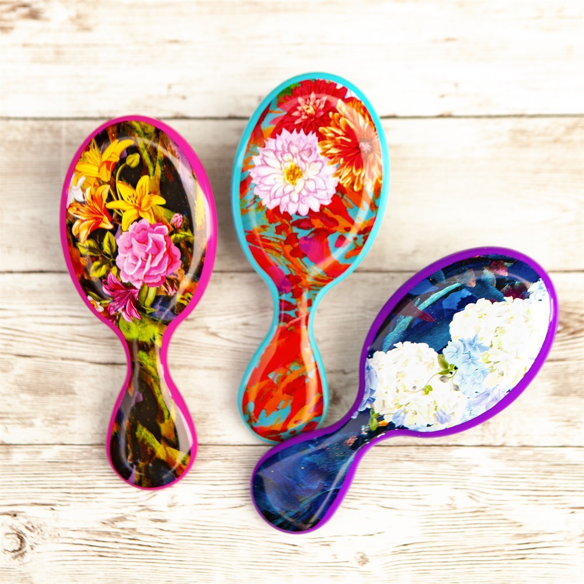 Wet Brush floral pattern detangler brushes with colorful flower designs on wooden background