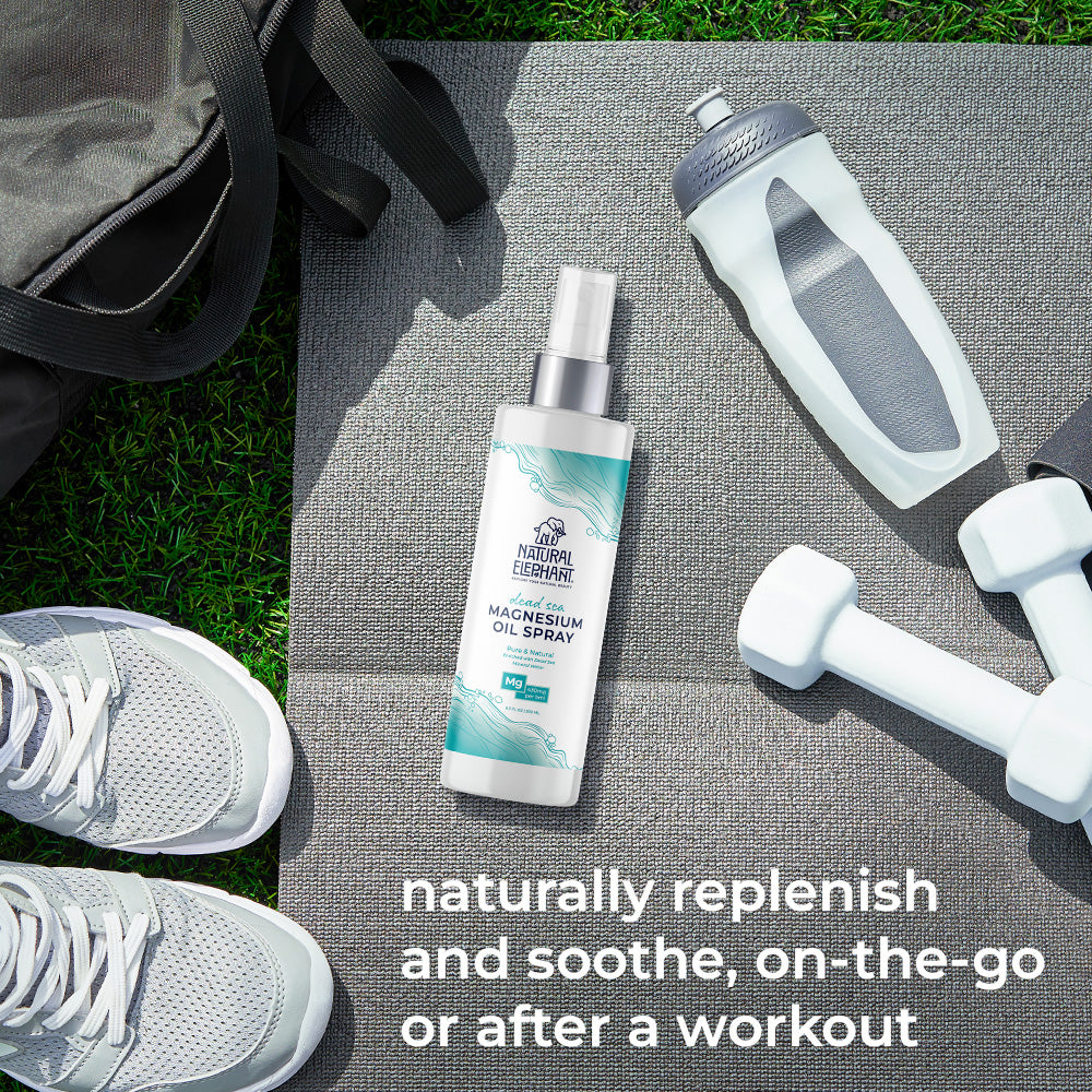Natural Elephant Dead Sea magnesium oil benefits spray bottle on workout mat with dumbbells and water bottle