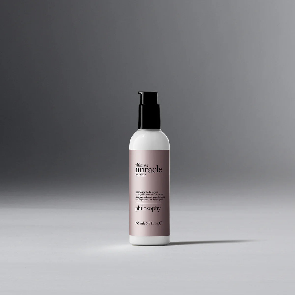 Philosophy Ultimate Miracle Worker resurfacing body serum bottle with pump dispenser on gray background