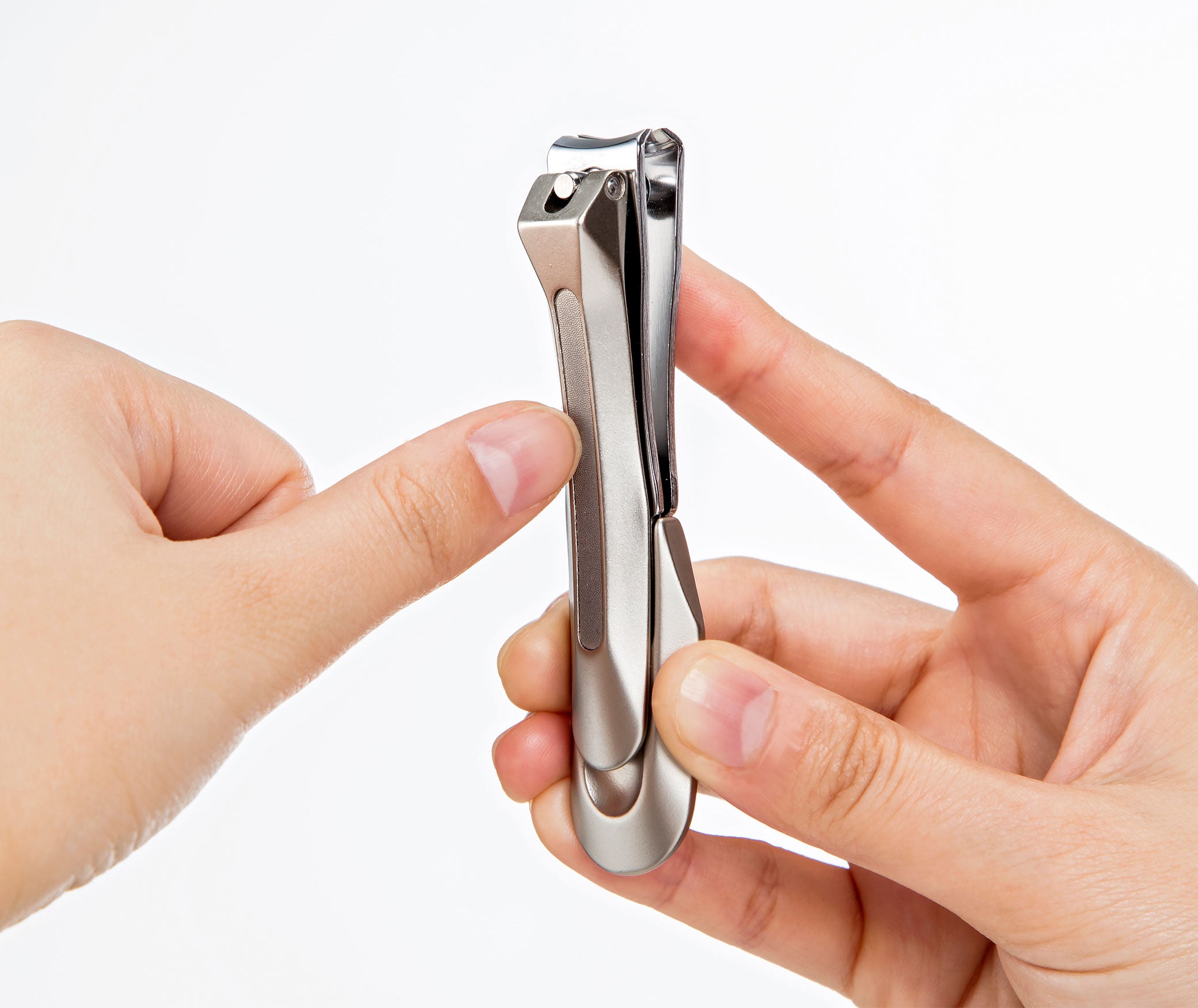 Seki Edge stainless steel nail clipper held between fingers for precise nail care