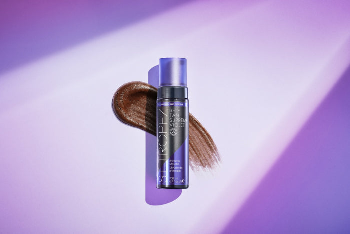 St. Tropez 6.7oz bronzer in purple bottle with brown bronzing swatch on purple background