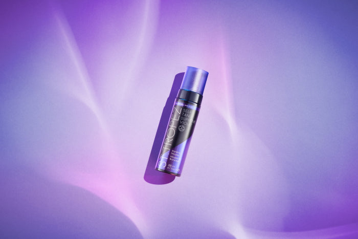 St. Tropez 6.7oz bronzer bottle with purple cap on a purple light background