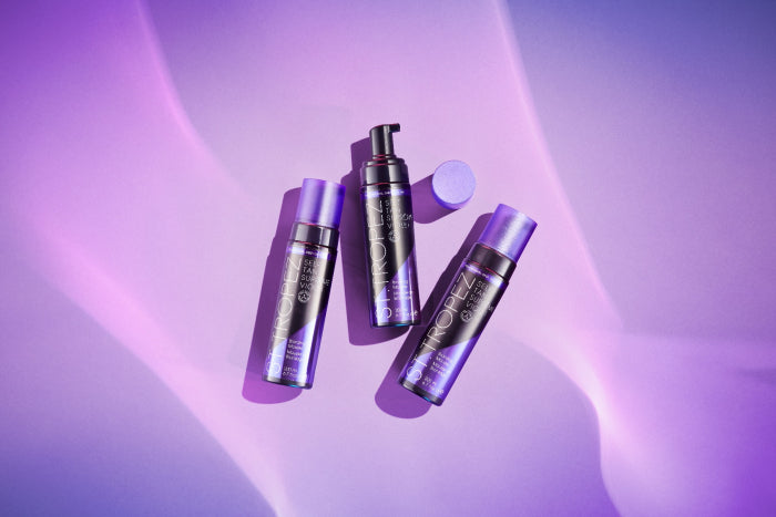 Three purple bottles of St Tropez 6.7oz bronzer displayed on a soft purple background