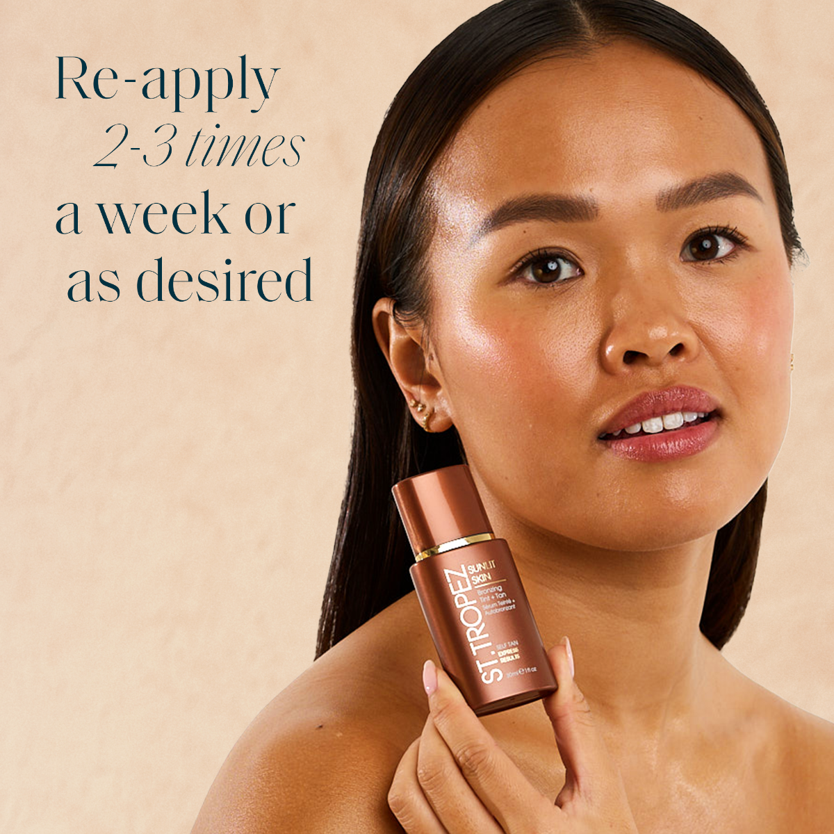 Woman holding St Tropez bronzing tint bottle with glowing skin and reapply instructions on beige background
