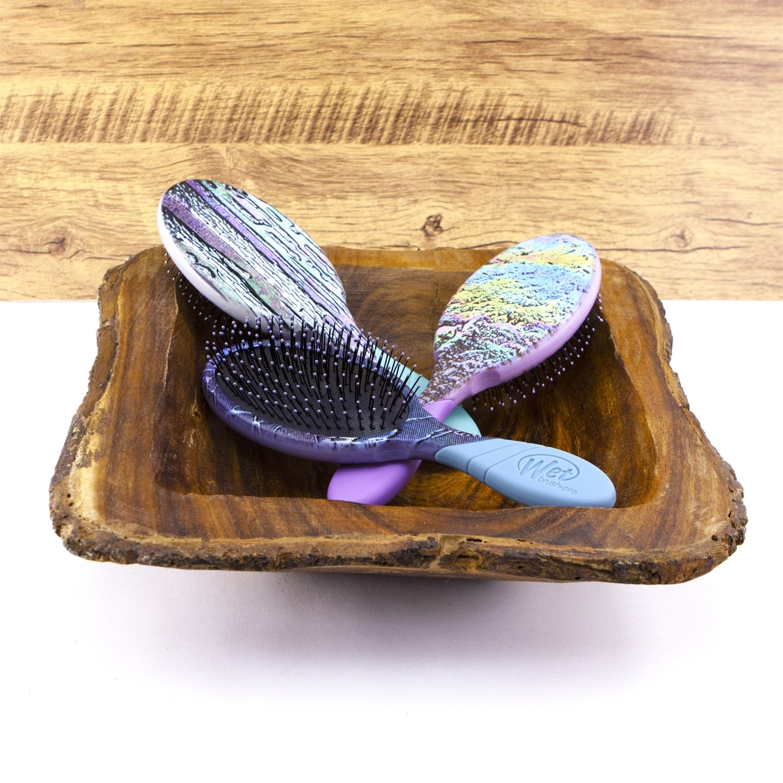 Wet Brush Super Slick hair brush with colorful marbled back and soft bristles in wooden bowl