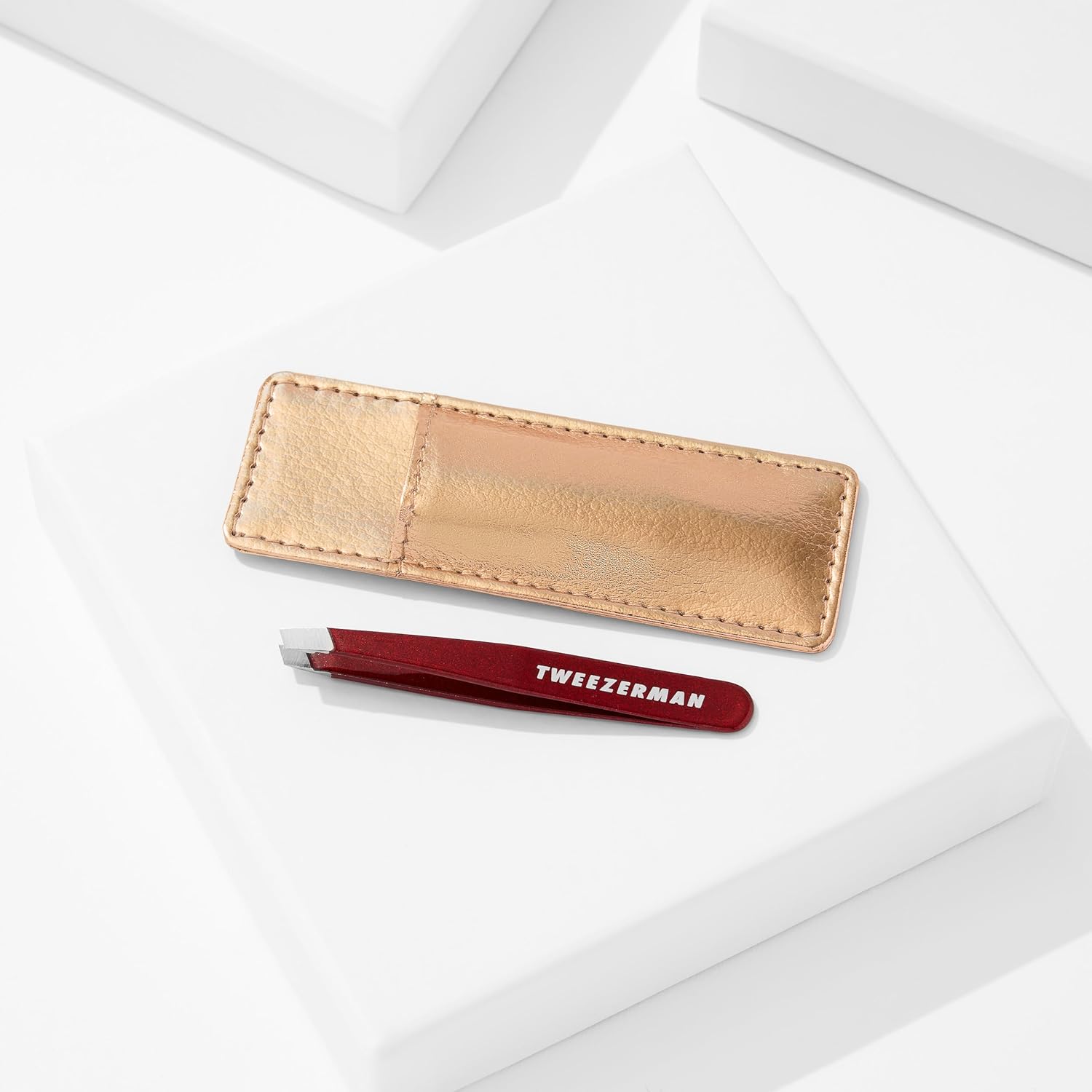 Tweezerman mini slant tweezer in red with a stylish gold case for precision grooming
