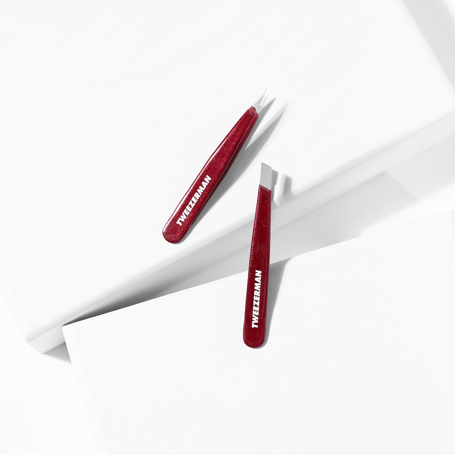 Tweezerman mini tweezer set featuring precision tweezers in a sleek red design.