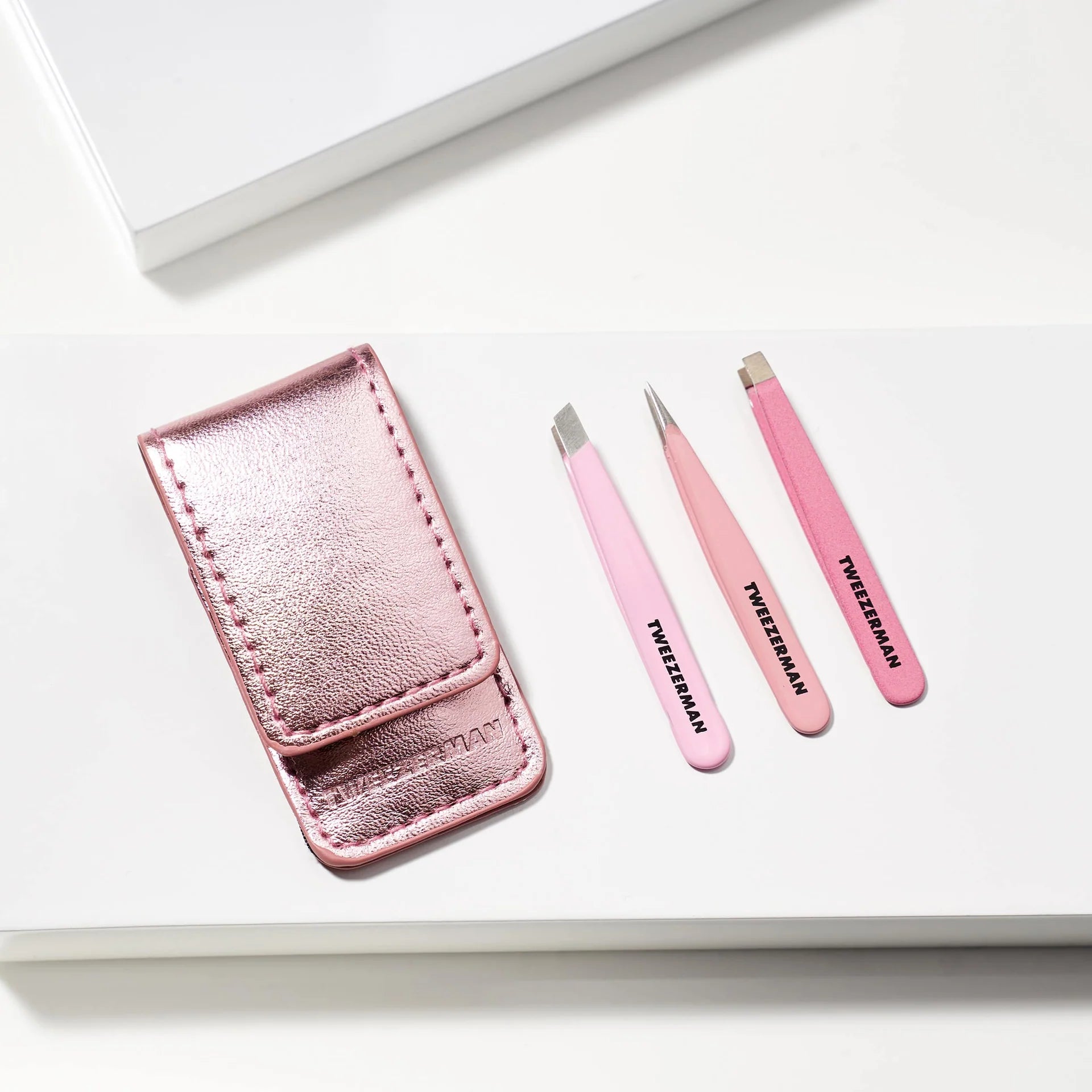 Tweezerman tweezer set in pink with three styles and a metallic case for precise grooming