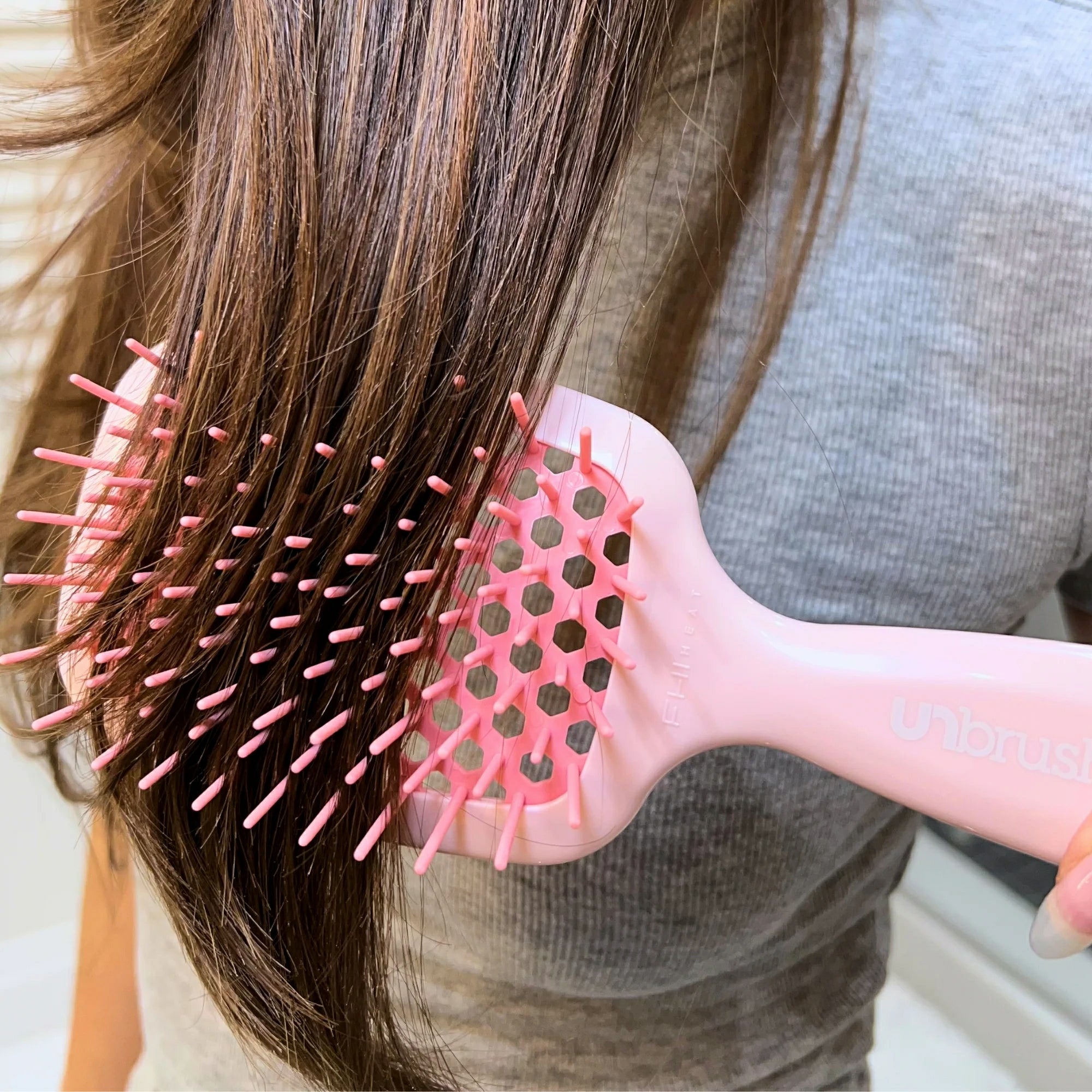 Unbrush original full sized hair brush in pink gently detangling long brown hair