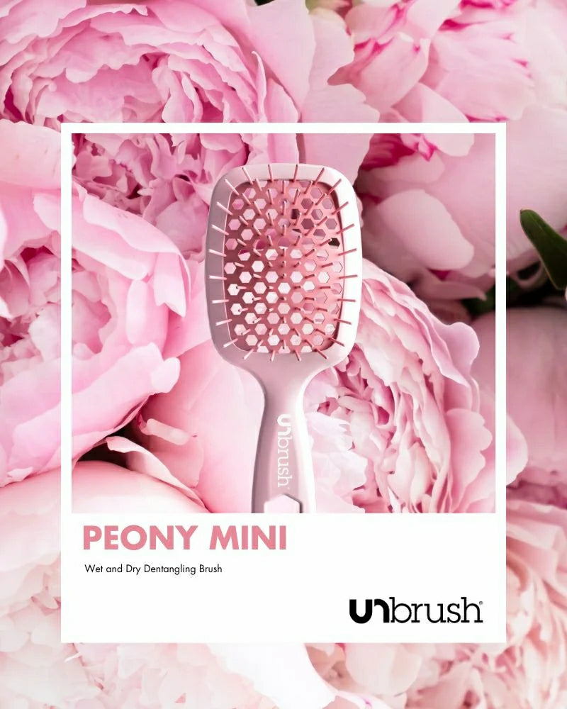 Unbrush glitter hair brush in pink Peony Mini design surrounded by pink peony flowers