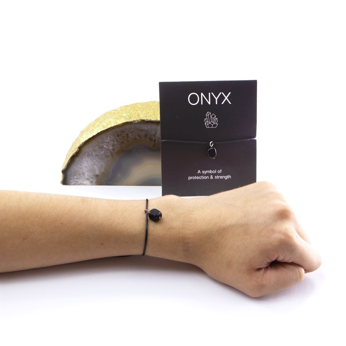 Wet Brush Mystical Crystal Detangler black onyx bracelet shown on wrist with protective strength symbol card