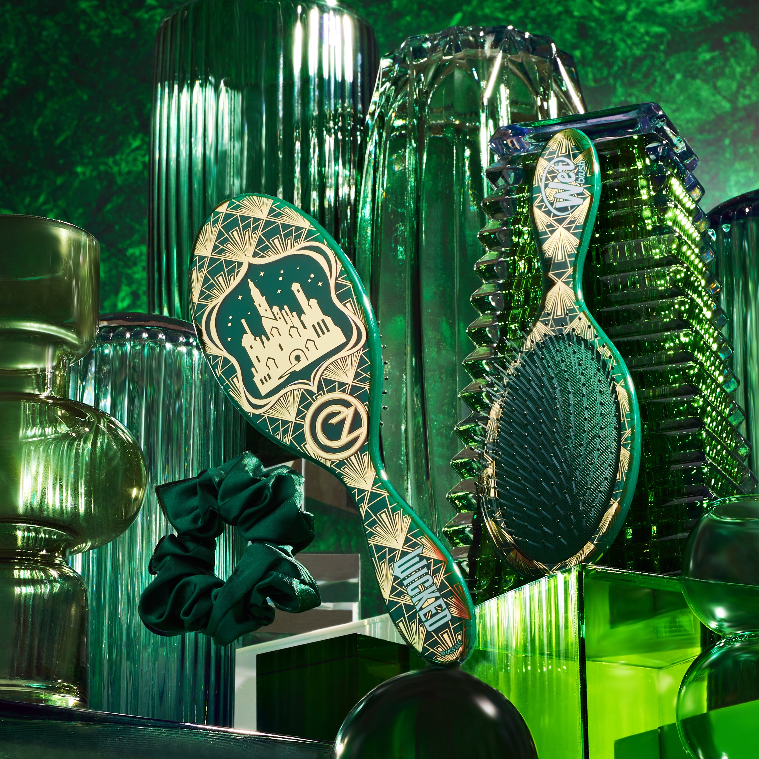 Wet Brush Wicked detangling brush with decorative design surrounded by green glass vases and scrunchies