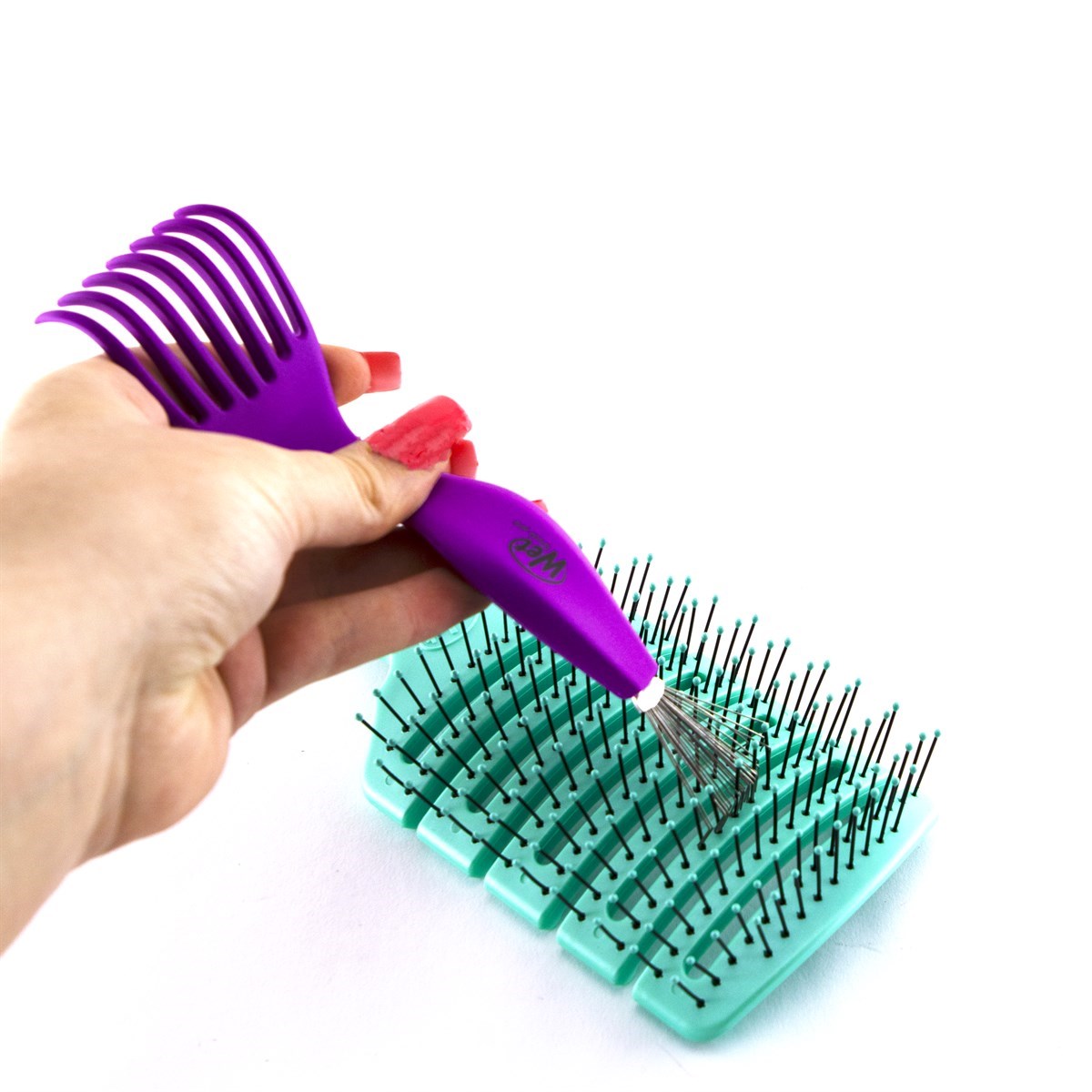 Wet Brush purple professional hair brush cleaner tool removing hair from green brush with black bristles