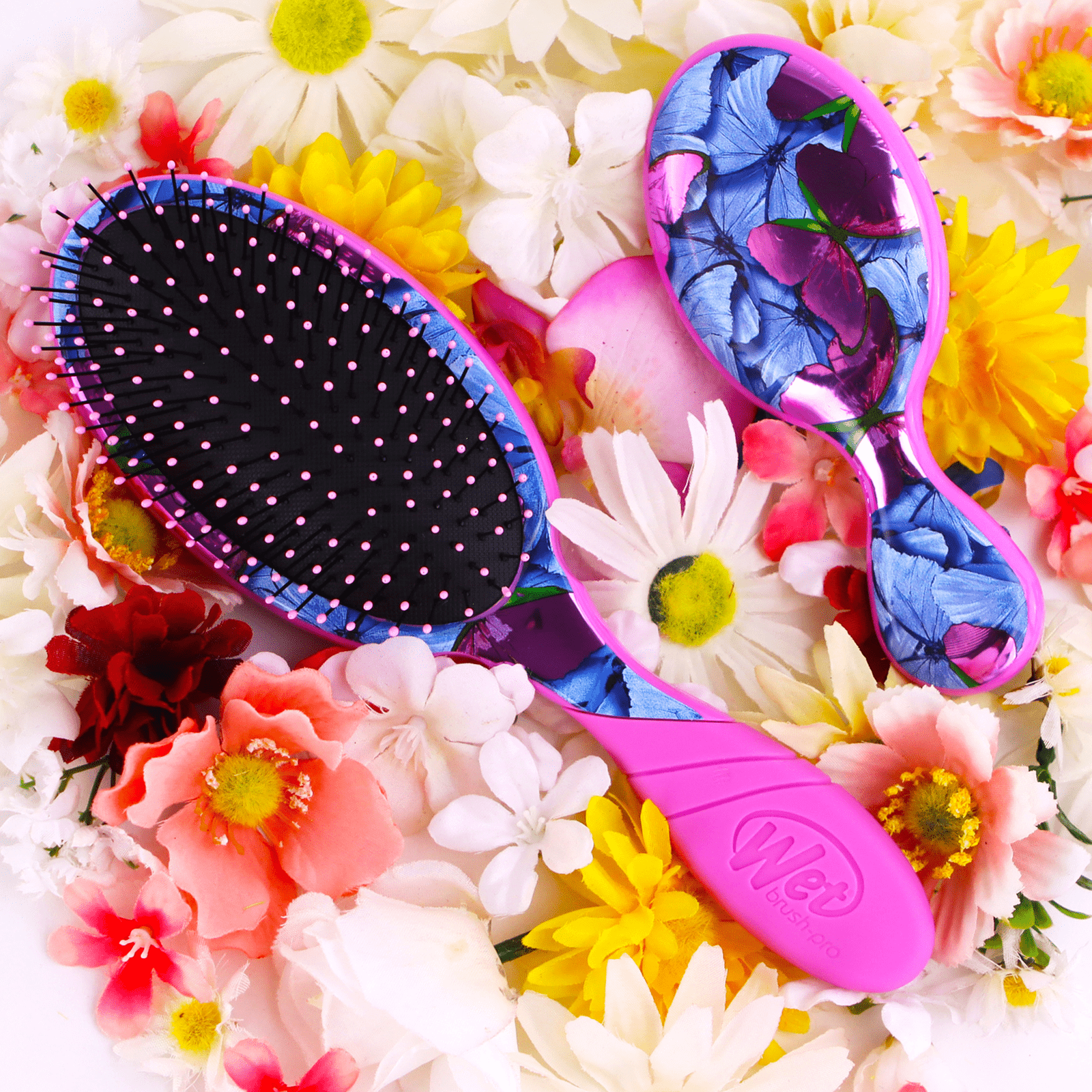 Wet Brush butterfly design hairbrush with pink handle and colorful butterfly pattern surrounded by flowers
