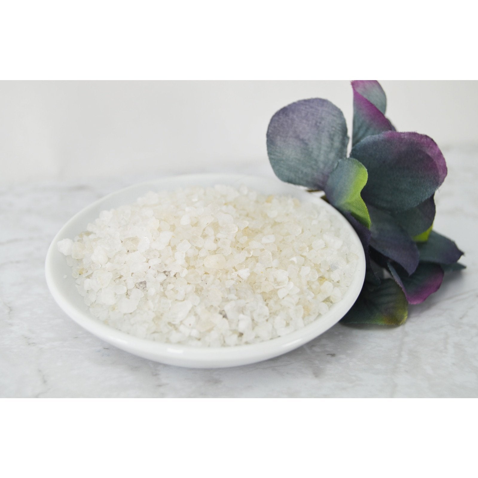 Natural Elephant Coarse Dead Sea Salt for Body in a white bowl with green leaves
