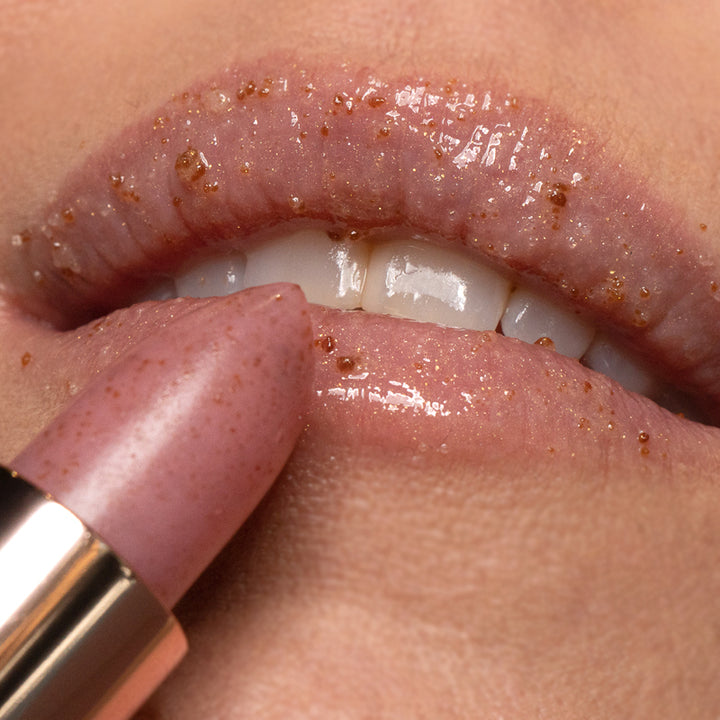 Karen Murrell natural lip scrub stick being applied to lips with visible exfoliating sugar granules