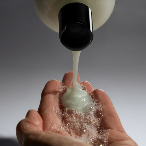 Philosophy Amazing Grace Jasmine shower gel being poured onto a hand with bubbles forming