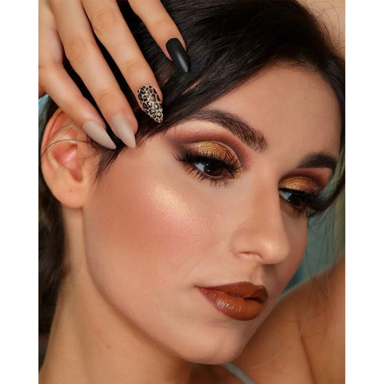Close-up of woman with dramatic eye makeup and Cala press on nails in matte black, beige, and leopard print