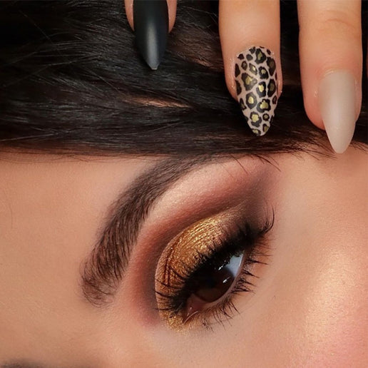 Close-up of hand showcasing Cala press on nails with leopard print, matte black, and nude designs