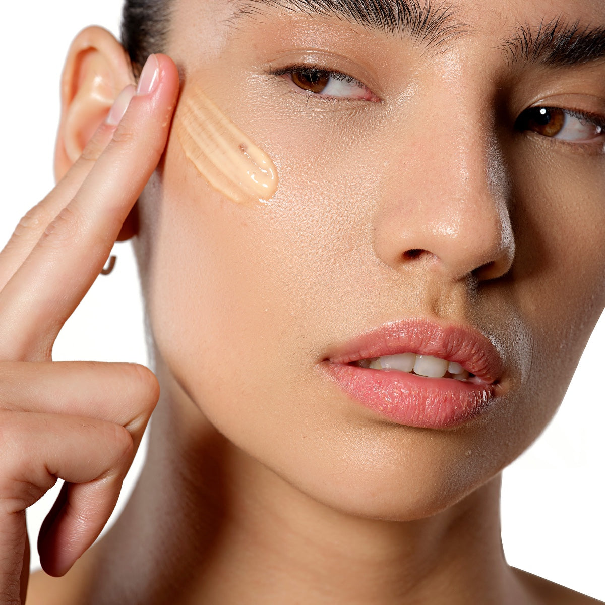 Allies of Skin model applying cream to cheek demonstrating 7 days to brighter skin kit results