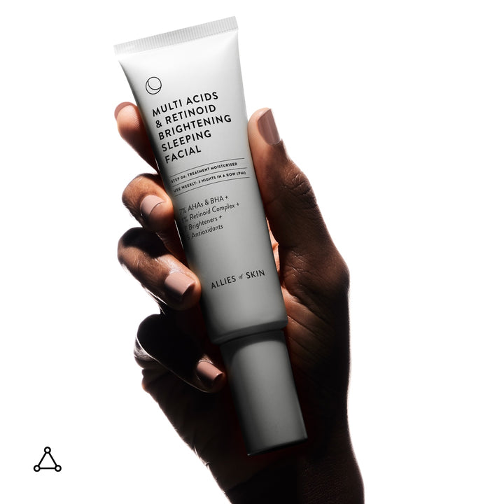 Hand holding Allies of Skin multi acid retinoid sleeping facial tube in white packaging