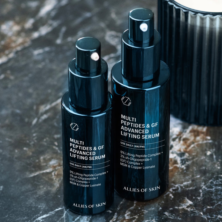 Allies of Skin multi peptide lifting serum duo in sleek navy pump bottles on marble countertop