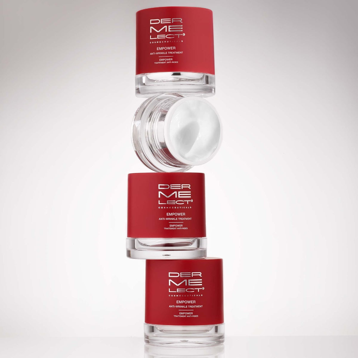 Dermelect Empower Anti-Wrinkle Treatment red jars stacked with one open jar showing white cream