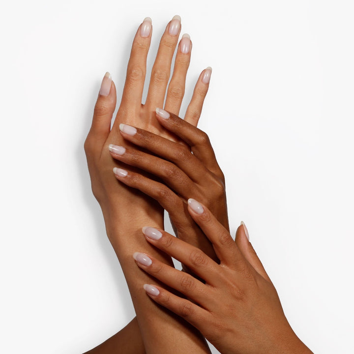 Dermelect Luminous Brightener review showing two hands with glossy nude manicure and even skin glow