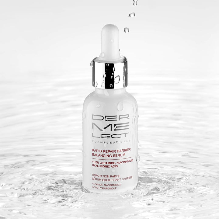 Dermelect Rapid Repair Serum white glass dropper bottle with silver cap reflected in rippling water and droplets