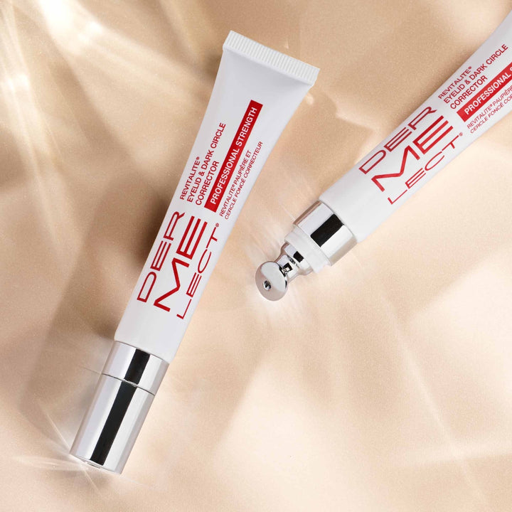 Dermelect Revitalite for dark circles two eye treatment tubes with metal cooling applicator on beige background