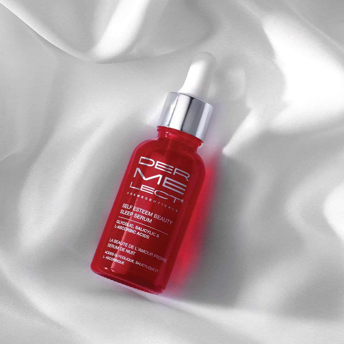 Dermelect Self-Esteem Beauty Sleep Serum red dropper bottle with silver cap on white satin background