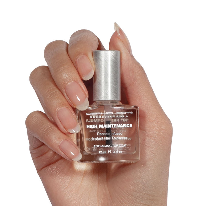 Dermelect High Maintenance bottle held in hand clear peptide infused nail thickener top coat for stronger glossy nails