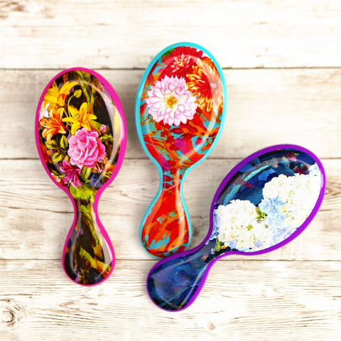 Wet Brush floral pattern detangler brushes with colorful flower designs on wooden background
