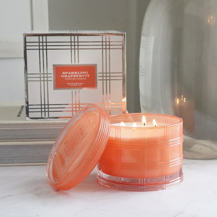 HomeWorx by Slatkin sparkling grapefruit scented candle in an orange glass jar with lid and decorative box
