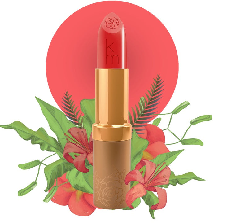 Karen Murrell natural lip tint coral red lipstick in gold tube with embossed KM logo and floral backdrop