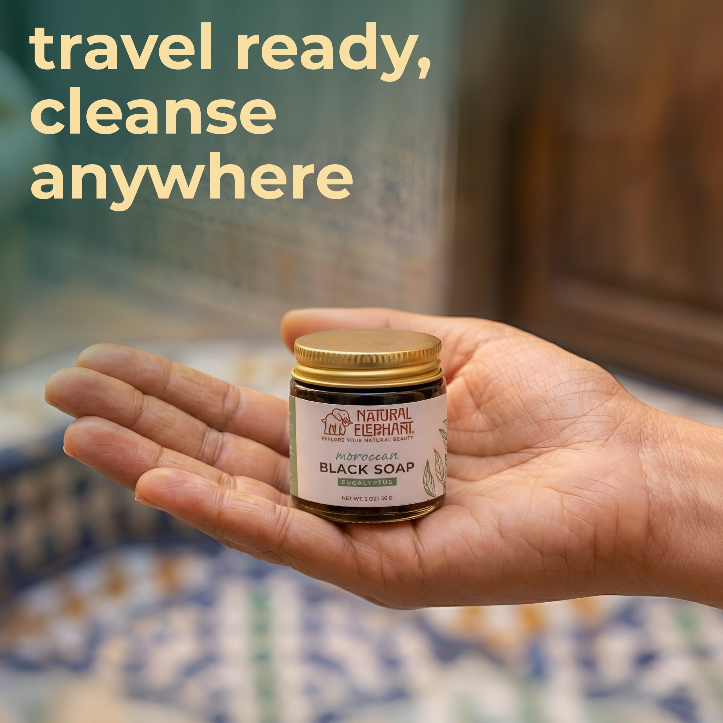 Natural Elephant Moroccan black soap travel size in a jar held in hand, ideal for on-the-go cleansing