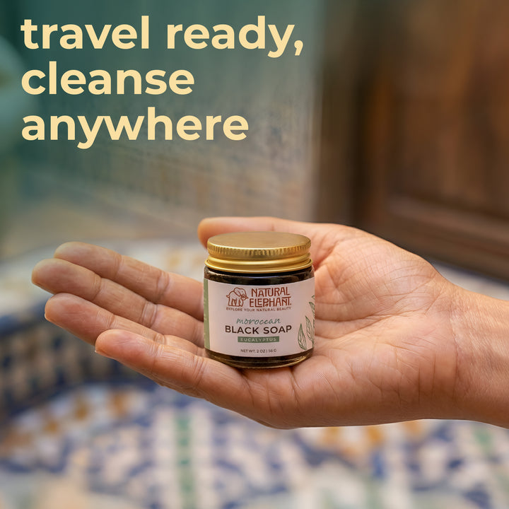 Natural Elephant Moroccan black soap travel size in a jar held in hand, ideal for on-the-go cleansing