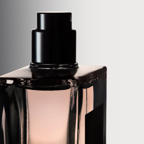 Close-up of Philosophy Amazing Grace Ballet Rose perfume bottle with black spray cap and soft pink fragrance liquid