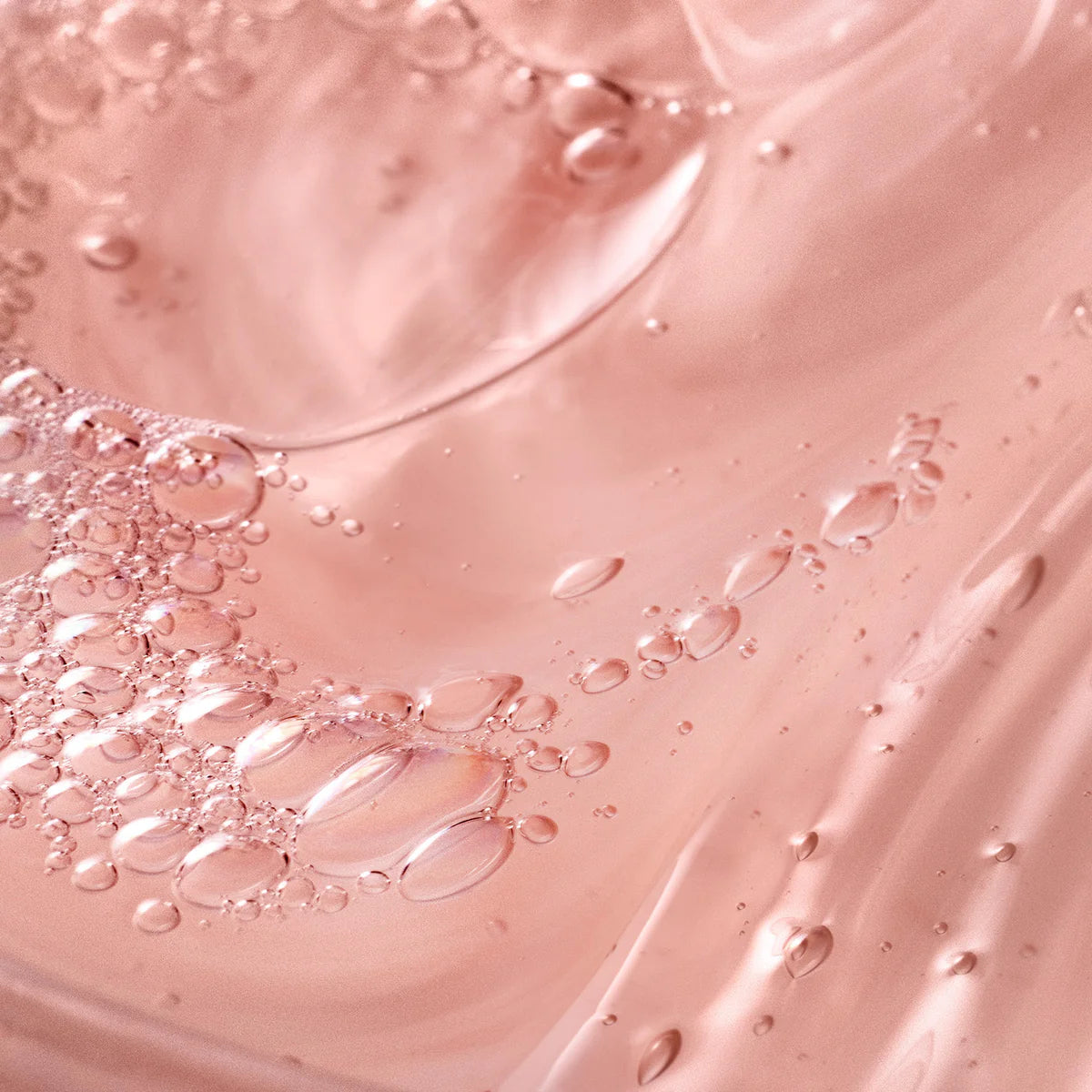 Close-up of clear pink gel texture with bubbles representing philosophy amazing grace shower gel