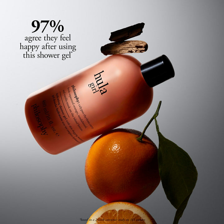 Philosophy Hula Girl shower gel bottle with orange fruit and wood pieces on gray background