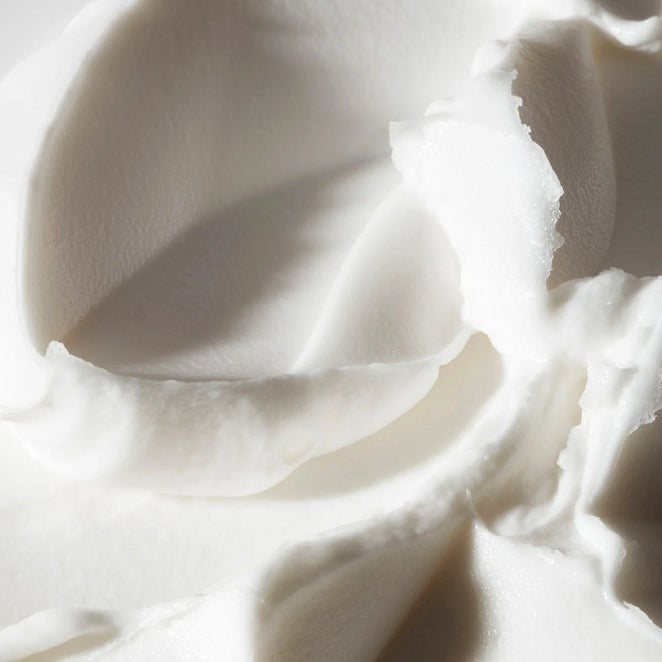 Close-up texture of Philosophy Radiant Grace body cream showing smooth white moisturizer